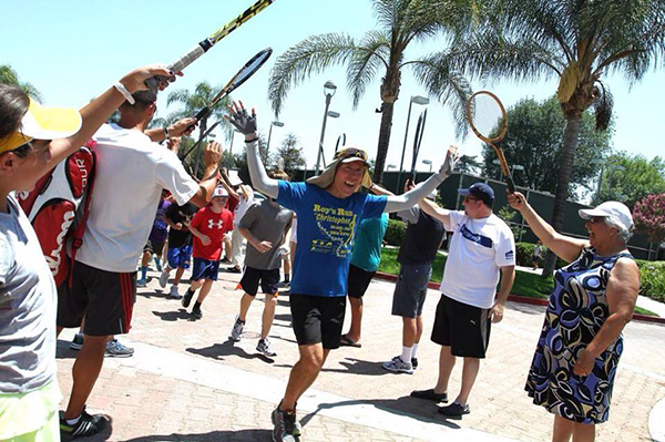 Onlookers at the Burbank Tennis Center cheer on Roy Wiegand during his July 4th Run For Christopher, during which the trumpeter and ultra-marathon runner ran 86 miles to benefit families and children suffering from cancer.